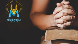 Persona che prega a mani congiunte sopra un testo sacro