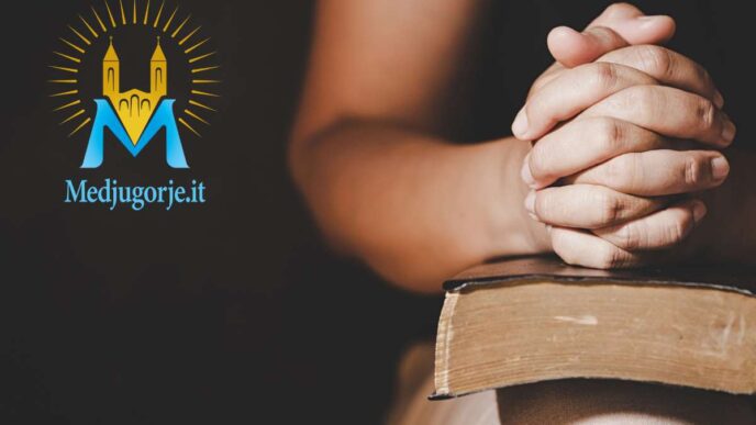 Persona che prega a mani congiunte sopra un testo sacro