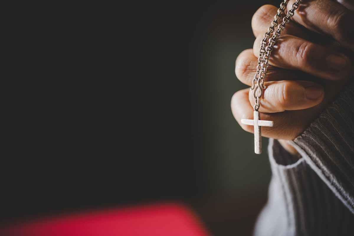 Mano che stringe il rosario