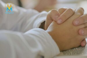 Mani congiunte su un testo sacro