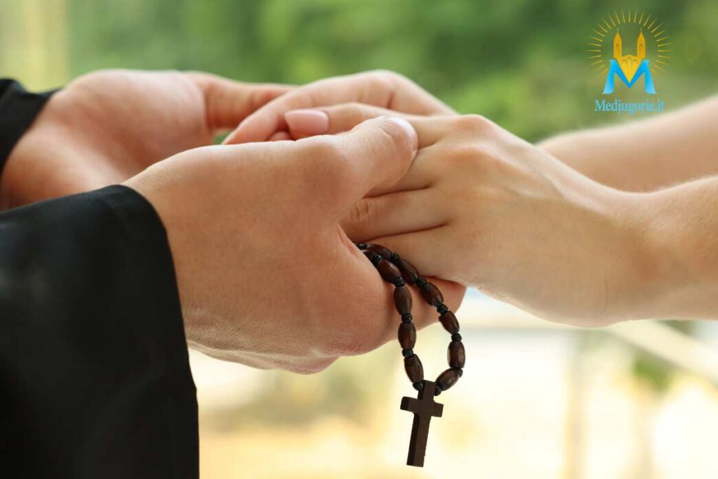 Mani che stringono altre mani e un rosario