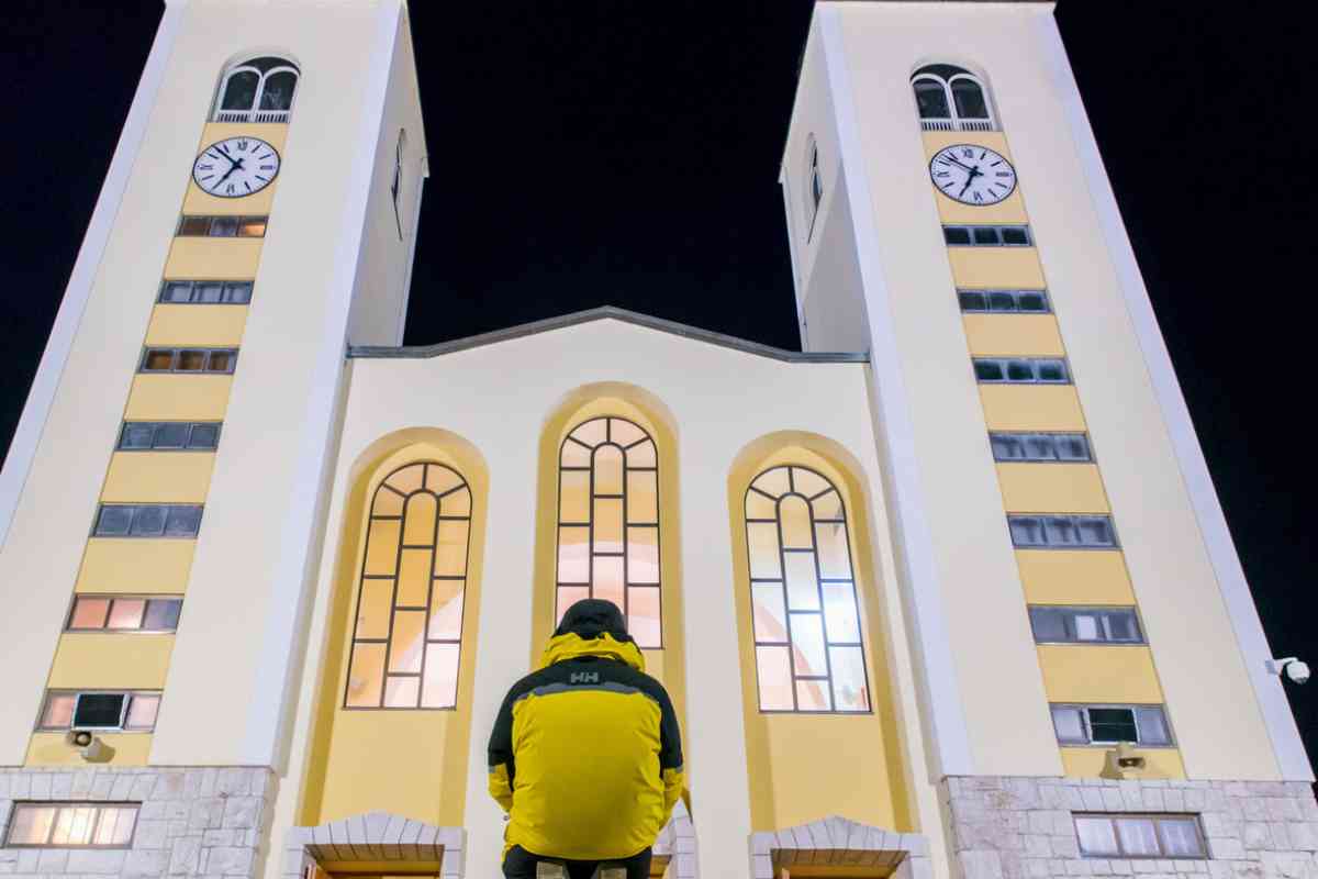 Un fedele prega in ginocchio davanti la chiesa di San Giacomo a Medjugorje