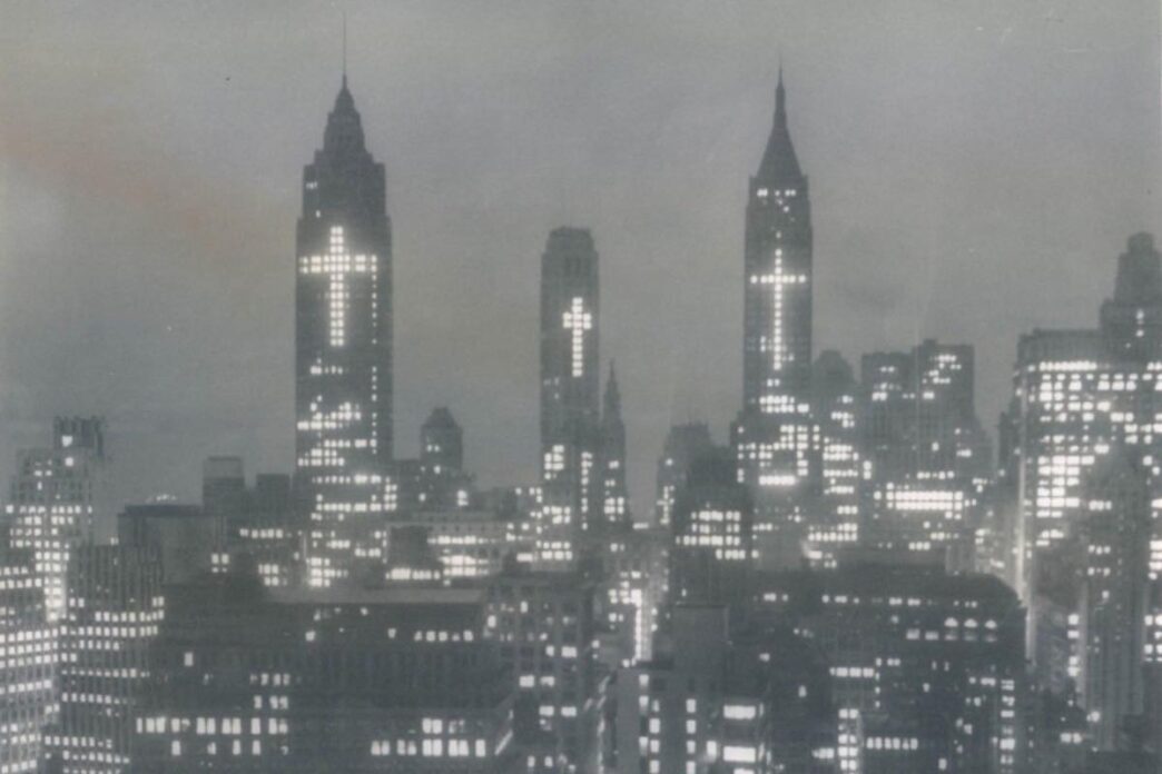 Certe immagini sembrano arrivare da un altro mondo. Non per distanza geografica, ma per distanza interiore. New York, 1956. Notte. I grattacieli del distretto finanziario illuminati in modo insolito: non pubblicità, non insegne. Croci.