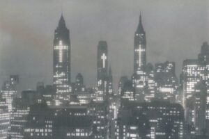 Certe immagini sembrano arrivare da un altro mondo. Non per distanza geografica, ma per distanza interiore. New York, 1956. Notte. I grattacieli del distretto finanziario illuminati in modo insolito: non pubblicità, non insegne. Croci.