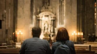 Coppia che prega insieme in una chiesa, illuminata dalla luce naturale