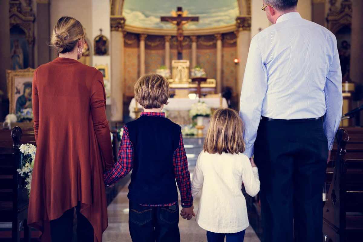 Coniugi con figli davanti all’altare
