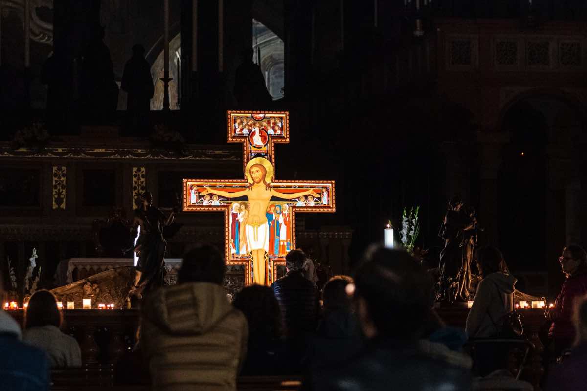 Fedele in preghiera davanti a una croce in una chiesa cattolica