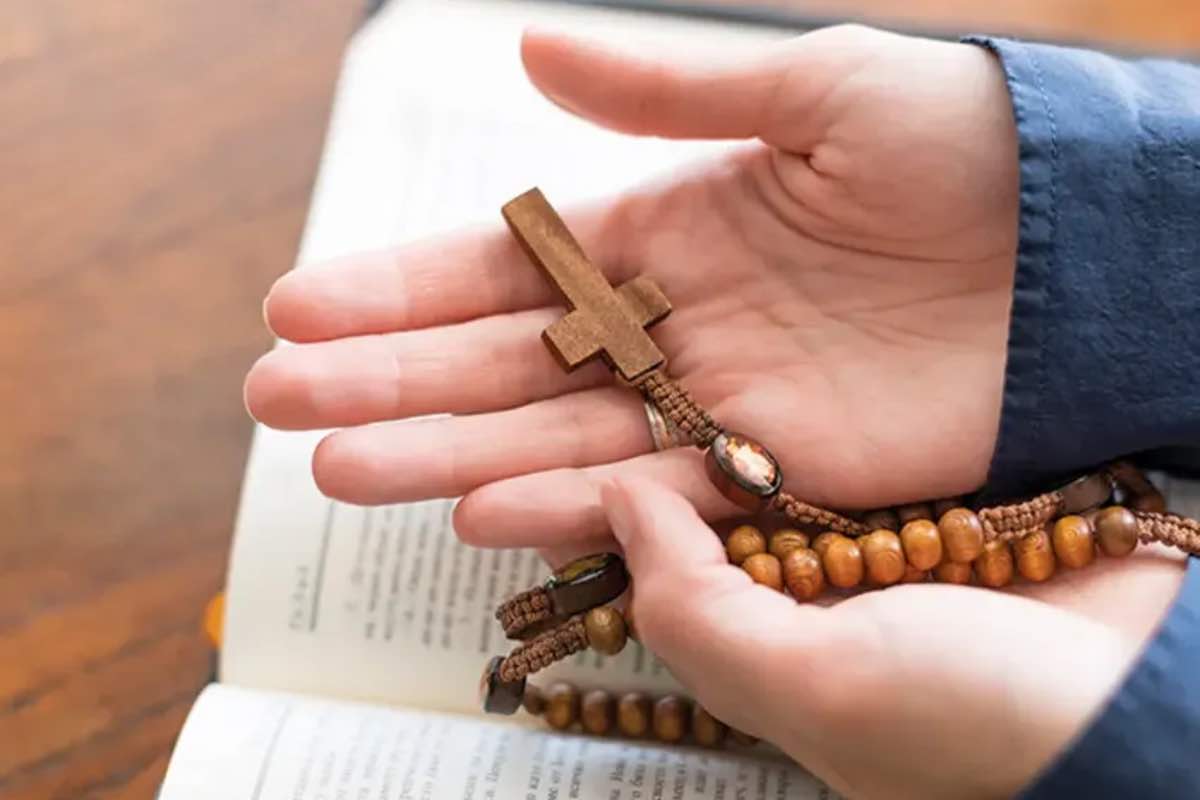Rosario appoggiato accanto a una Bibbia aperta durante un momento di preghiera