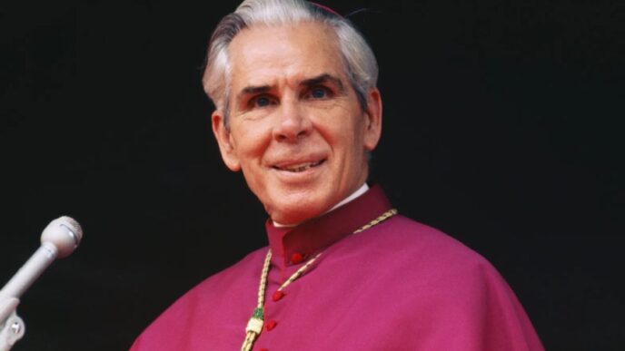 Mons. Fulton Sheen in abito vescovile davanti a un microfono