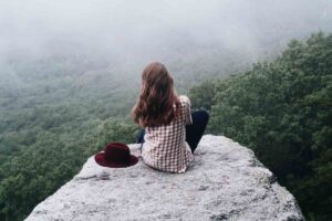 Persona che riflette meditativamente davanti a un paesaggio naturale