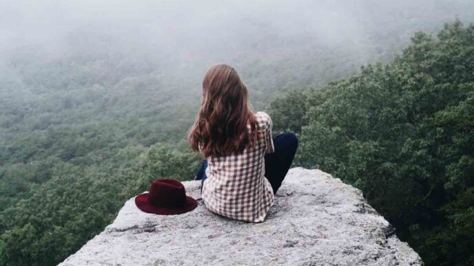 Persona che riflette meditativamente davanti a un paesaggio naturale